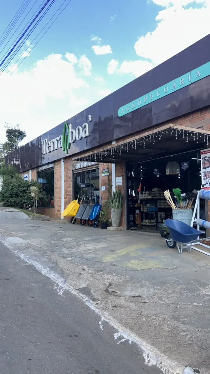 Fachada da Terra Boa em dia de céu azul, com carrinho de mão na calçada